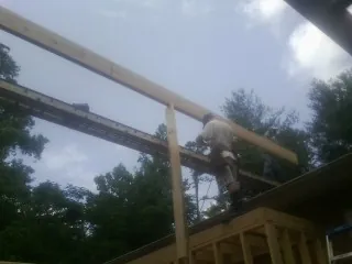 Carpenter setting a ridge beam over a new addition frame — Ice Dam Removal by Roofing Brothers in Harrogate