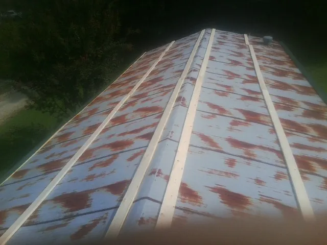 Rusted metal roof panels with new wood purlins before replacement — Storm Damage Roof Repair in Harrogate by Roofing Brothers
