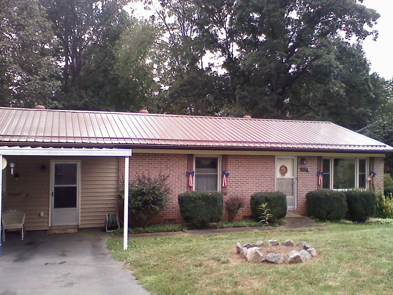 Bronze metal roof and carport on a brick ranch home — Roof Repair work by our crew in Harrogate